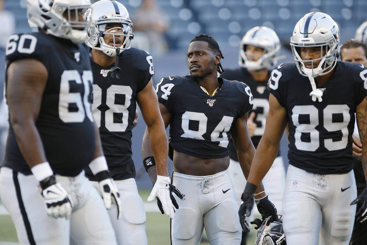 Oakland’s Antonio Brown – helmet off – and teammates gather before an NFL preseason football game against the Packers on Thursday in Winnipeg, Manitoba. 