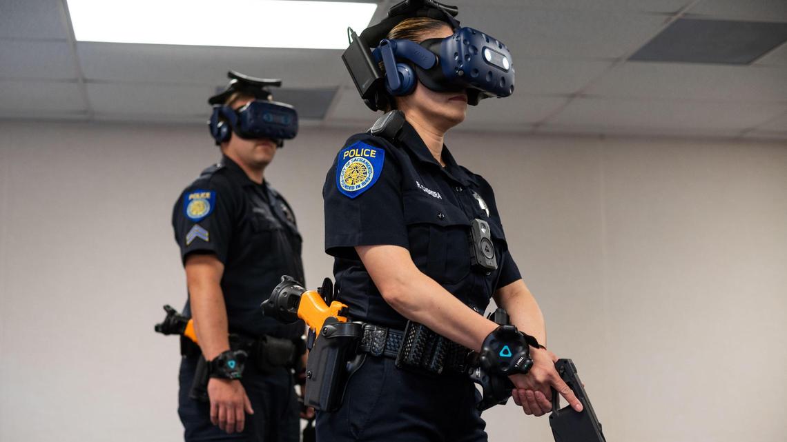 Sacramento Police Department Cpl. Rosalia Cabrera, right, holds a simulated stun gun while demonstrating with Cpl. Luke Moseley the department’s new virtual reality training helmet and gear Wednesday, May 5, 2021, at the Sacramento Police Academy.