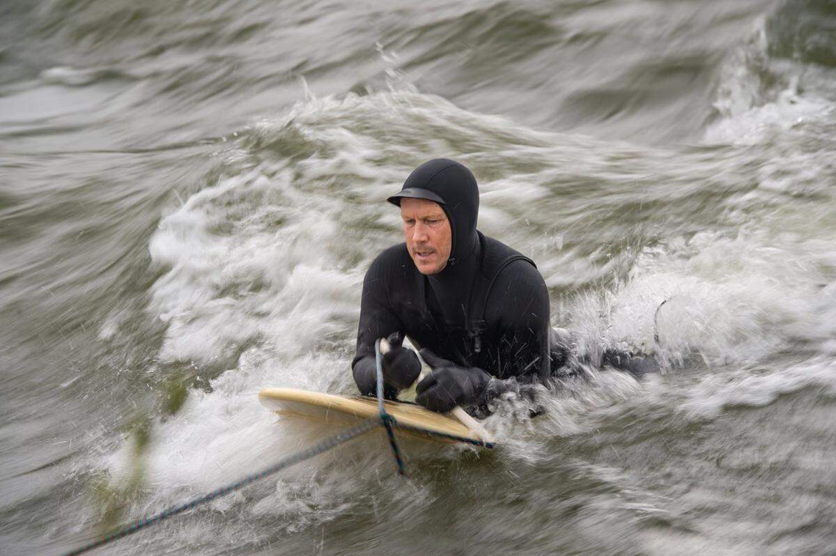 Mark Divittorio uses a rope tied to a tree to get into the middle of the channel to ride a wave to river surf on Sunday, March 12, 2023, in the American River near Carmichael.