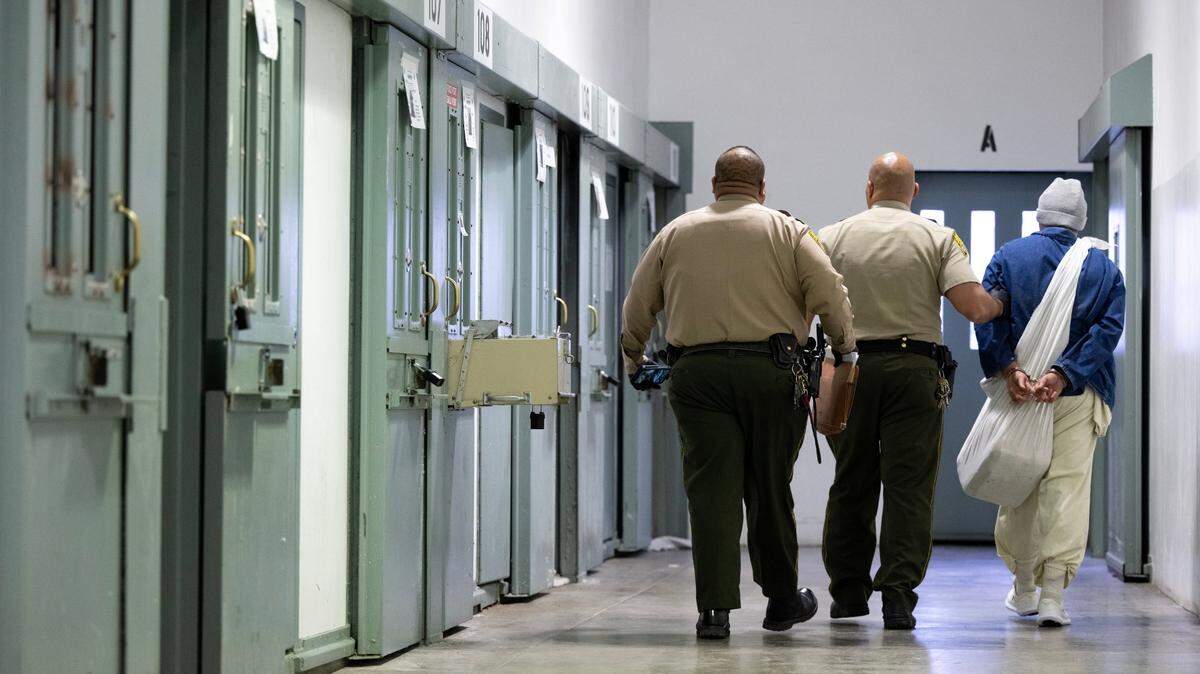 Officers escort an inmate at California State Prison, in Sacramento in 2024. 