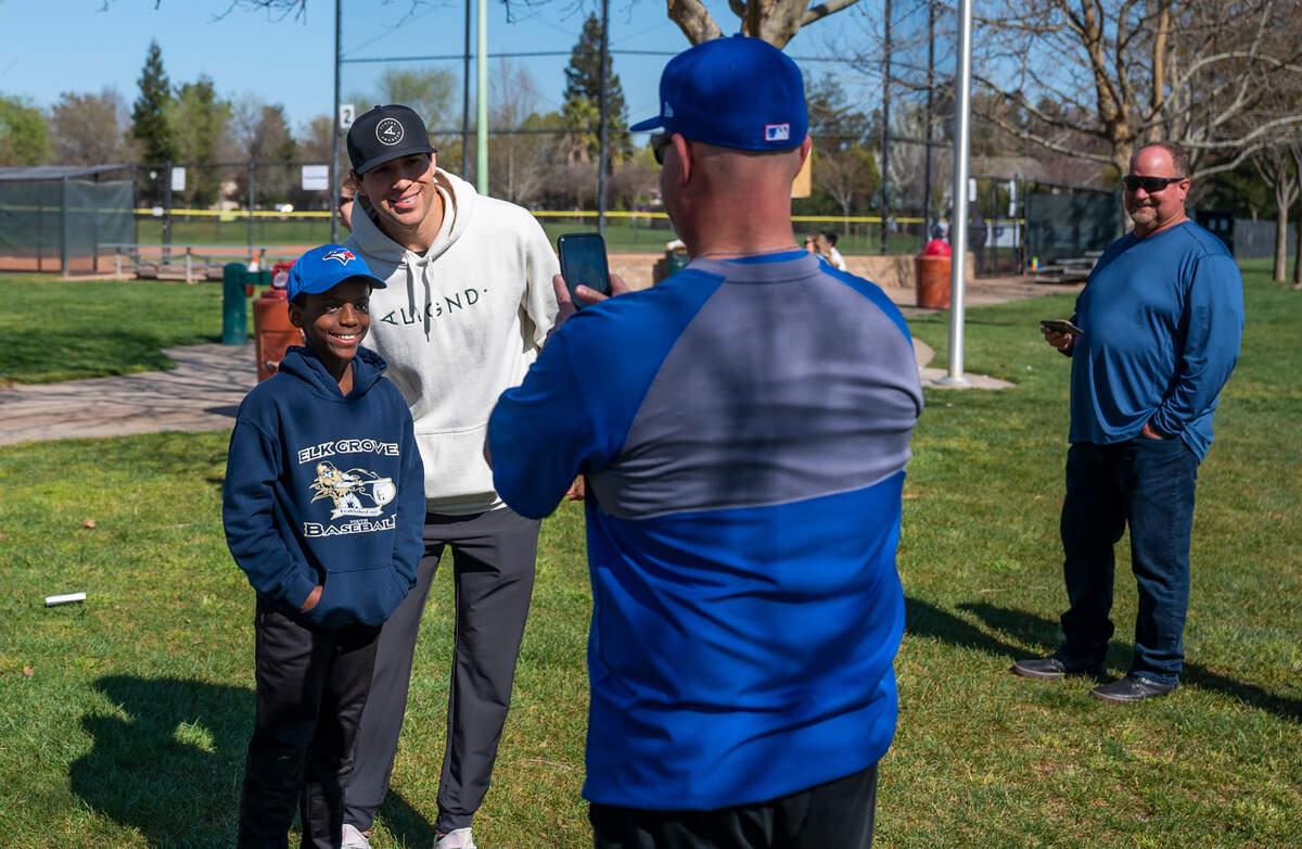 Elk Grove youth baseball player Ty Feaster has his picture taken with St. Louis Cardinals outfielder Dylan Carlson on March 6. Carlson’s father Jeff, who coached his son to championships and a first-round draft spot, watches at right.