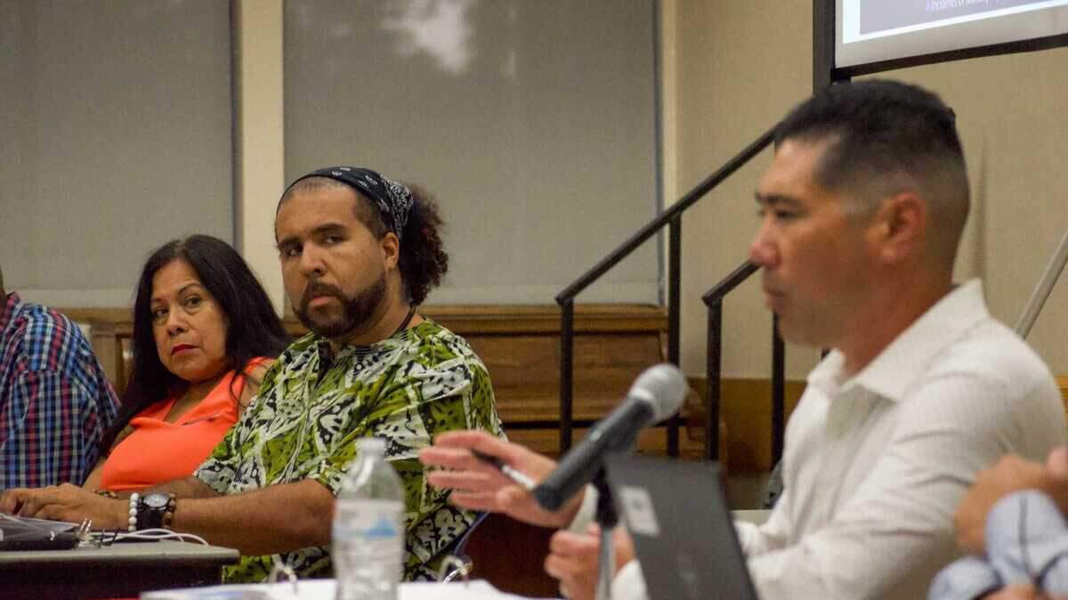 Ramona Landeros and Keyan Bliss listen as Lieutenant Jeff Shiraishi explains the police military usage report to the community on Monday, July 22, 2024. The meeting addressed concerns from the community around the use of military-equipment.