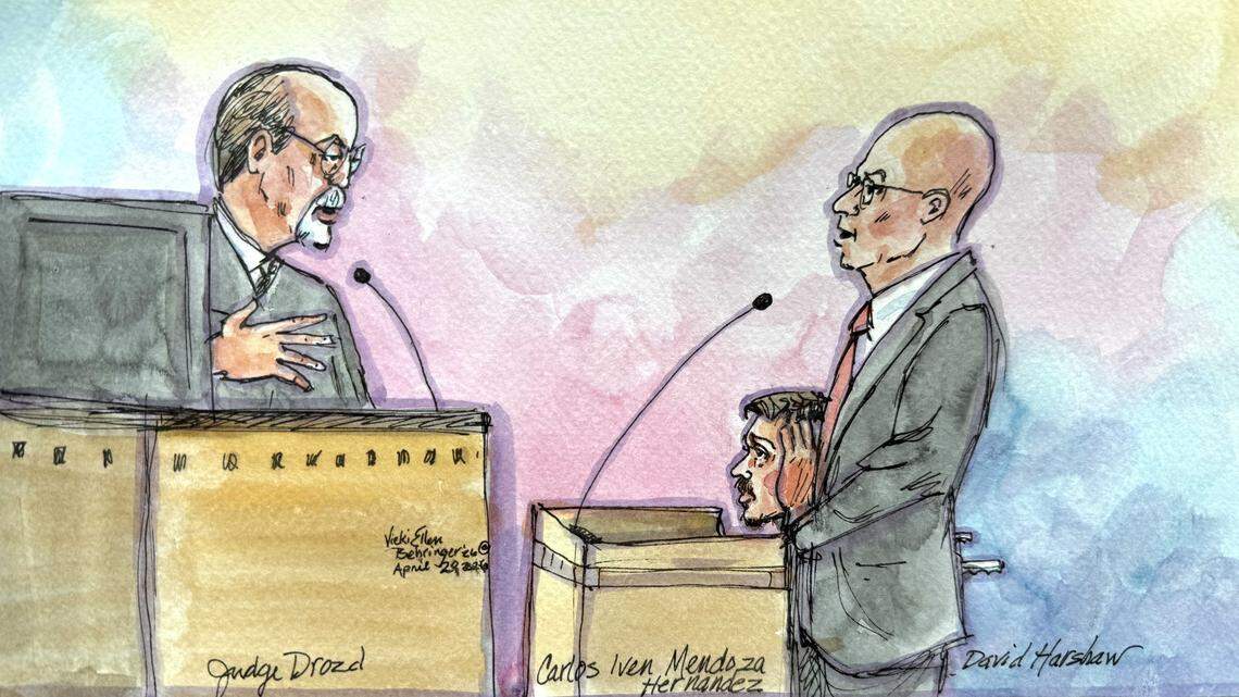 U.S. District Judge Dale Drozd, left, speaks with defense attorney David Harshaw, right, as Carlos Ivan Mendoza Hernandez, center, sits in a wheelchair during a federal court hearing in Sacramento on Monday, April 20, 2026. Drozd ruled that Mendoza Hernandez will remain in custody pending trial on a charge of assaulting a federal officer with a deadly weapon after prosecutors challenged an earlier release order.