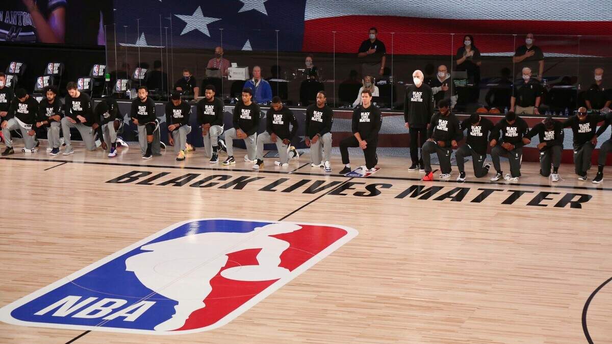 Kings players and Spurs players kneel before their game Friday night.