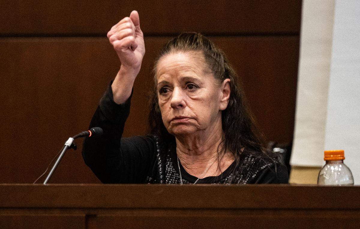 Victim Kimberlee Guillory makes a downward stabbing motion, describing the knife attack that ripped open the tent where she living in Davis and sent her to the hospital, as she testifies on May 7 during the trial of Carlos Reales Dominguez in Yolo Superior Court in Woodland.