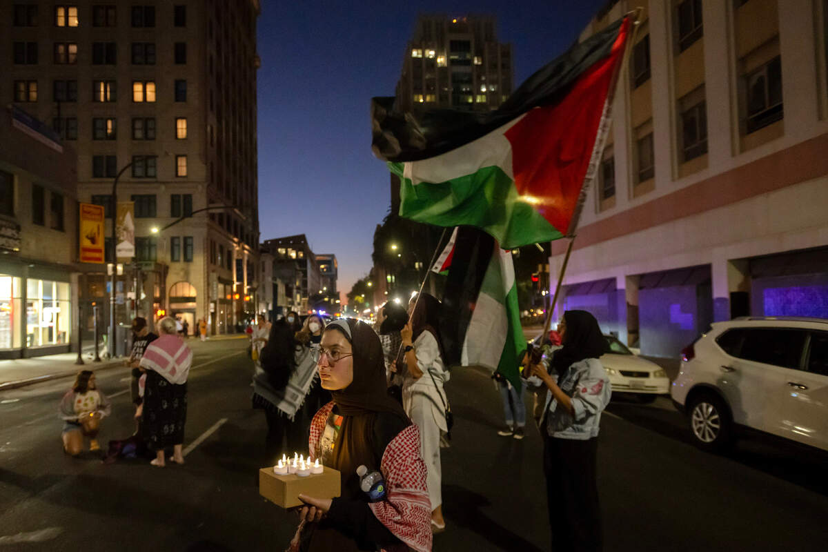 Doonya Mahmoud holds candles on J and 10th streets during a candlelight vigil by the Sacramento Regional Coalition for Palestinian Rights opposing the conflict in Gaza on Monday in downtown Sacramento. 