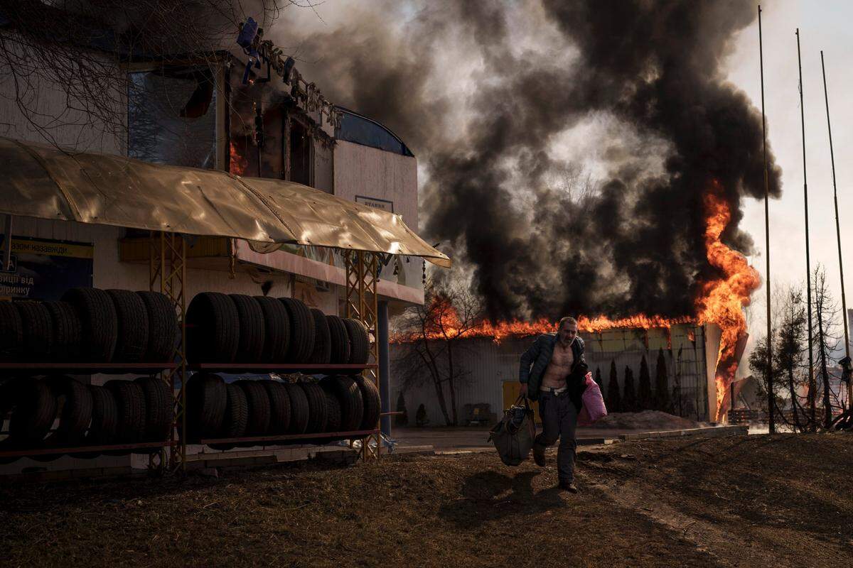 A man recovers items from a burning shop following a Russian attack in Kharkiv, Ukraine on Friday.