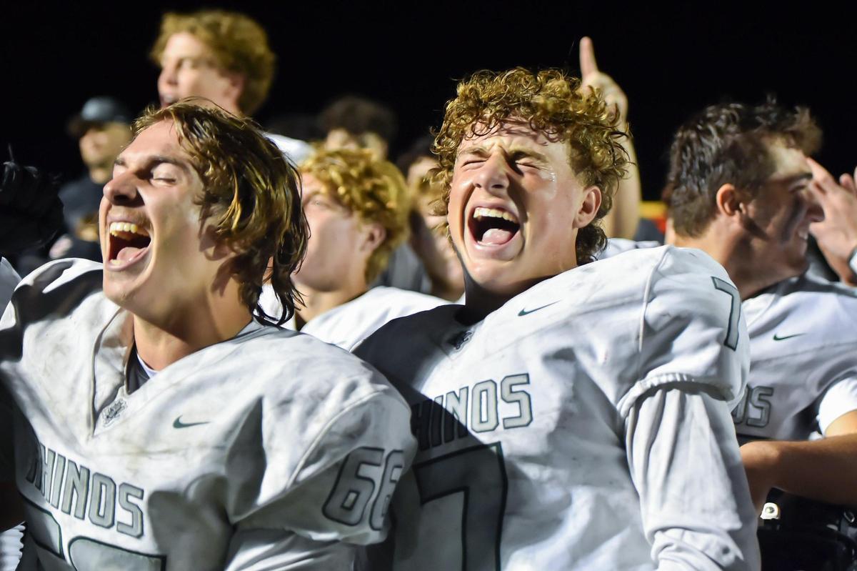The Twelve Bridges Raging Rhinos’ Raiden Podulka (66) and Ryan Wanger (7) cheer after defeating the Sutter Huskies for a league title on Thursday, Oct. 12, 2023, at Sutter Union High School.