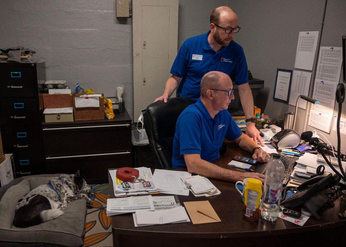 Pucci’s Pharmacy owners Clint Hopkins and Joel Hockman, who are married, do some office work with their dog Allie sleeping close by on Wednesday. Pucci’s is the only pharmacy in the Sacramento area offering the monkeypox vaccine. Customers can schedule appointments online.