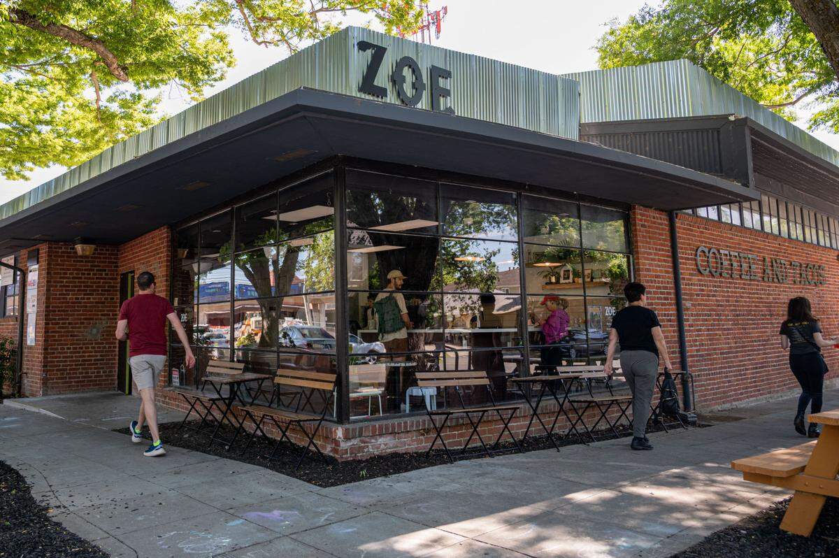 Customers walk in front of Zoe Coffee and Tacos in the Newton Booth section of midtown Sacramento on Tuesday.