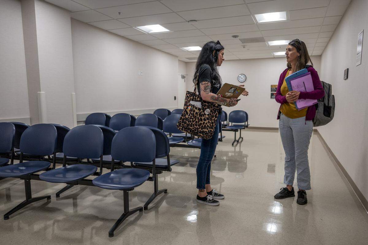 Heidi Phipps, left, gives Jessica Drizin, right, a tour of the John E. Moss federal building in downtown Sacramento between immigration court hearings on July 22.