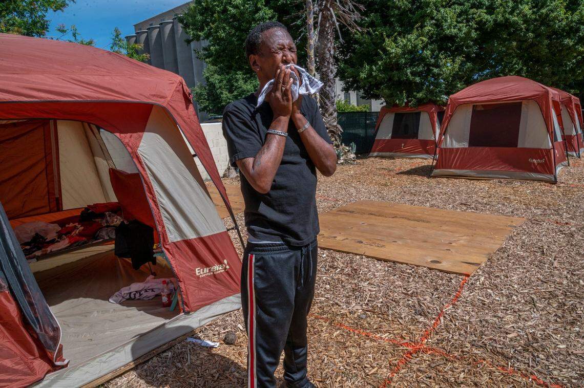Uartine Gentry Jr, 59, wipes sweat from his face in front of his new tent at a temporary Safe Ground shelter in Sacramento on Friday, June 10, 2020. The encampment provides a bathroom, shower and running water and is self governed. “It’s safe, it’s gated and I’m tired of being out here,” said Gentry who moved in 3 days ago.