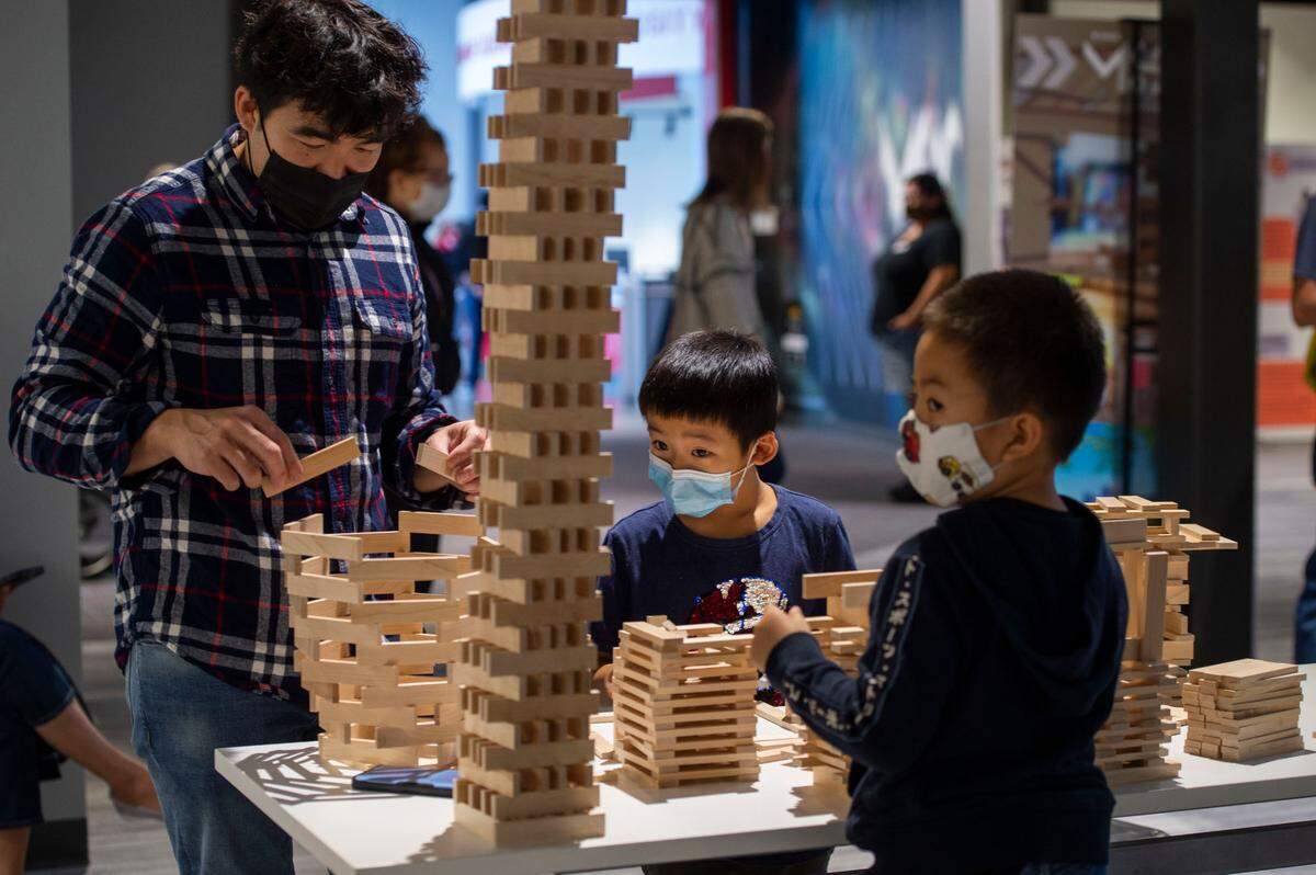 Tom Saephan builds blocks with his son Bradley, 8, center, and a new friend Leon, right, on opening weekend of SMUD’s new Museum of Science and Curiosity, MOSAC, on Saturday, Nov. 13, 2021.