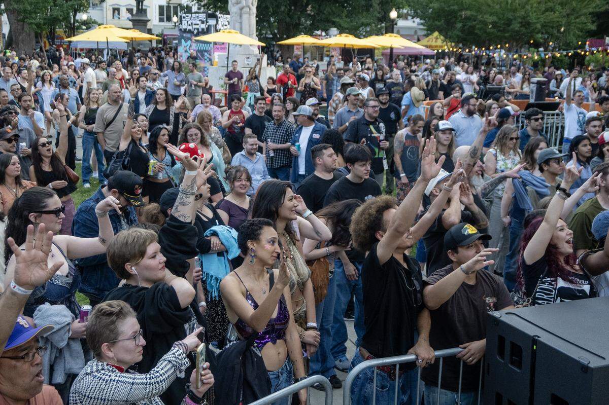 Concert attendees cheer during a performance at Concerts in the Park across from Sacramento City Hall on Friday.