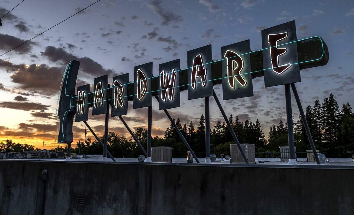 The sun sets behind the Hollywood Hardware neon sign, which has found a new home at the Otto Construction headquarters, in downtown Sacramento earlier this month.
