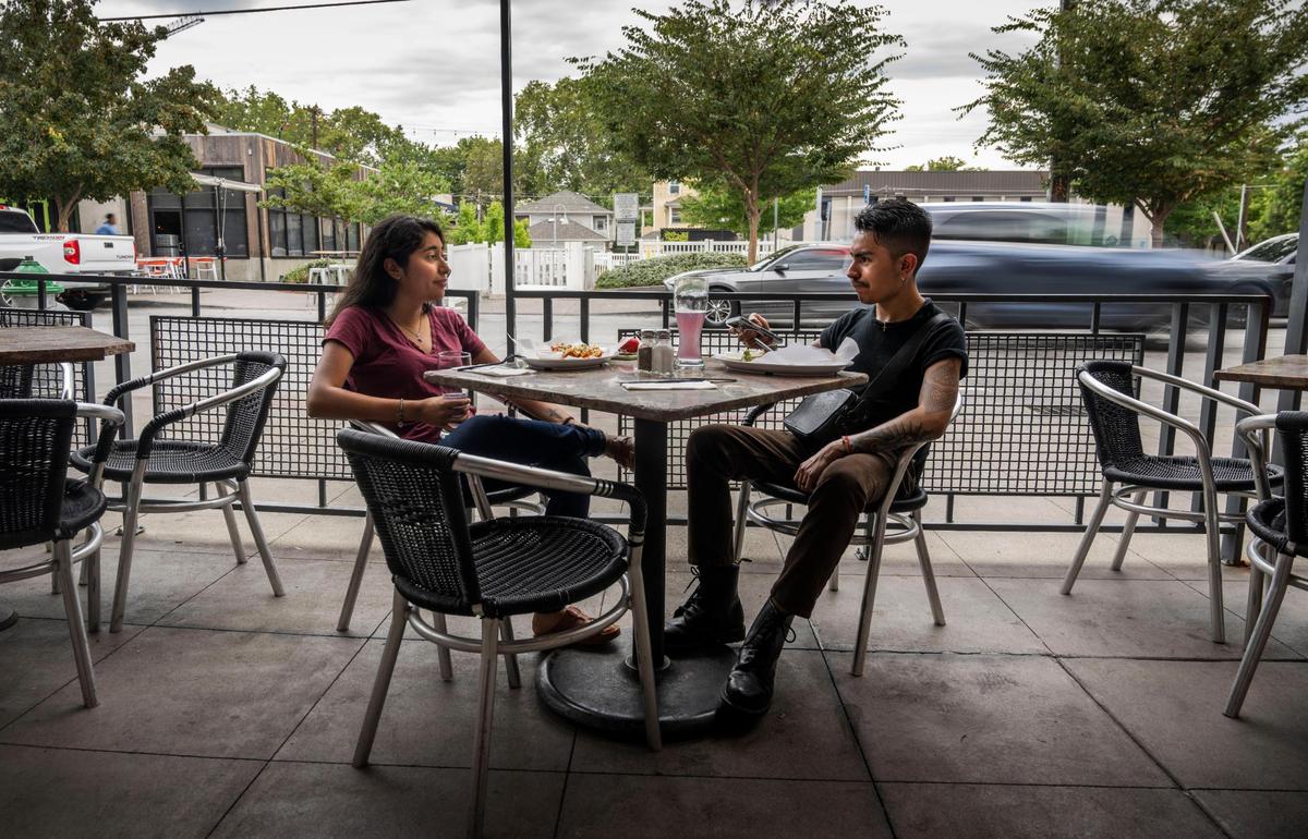 Victoria Blanco and Cesar Medina, both of Sacramento, have lunch at Burgers and Brew on Monday. The City of Sacramento has reopened R Street to traffic after closing it during the pandemic to help local business.