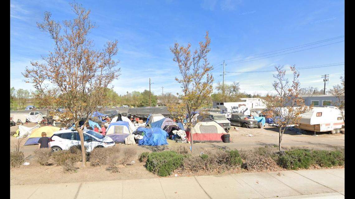 Unhoused individuals are seen camping at a city lot at Colfax Street and Arden Way in Old North Sacramento in March 2022. The city cleared people off the property and installed a fence for $617,000.