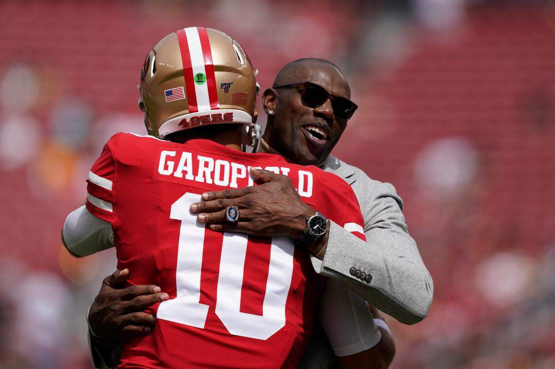 Former San Francisco 49ers wide receiver Terrell Owens, right, hugs quarterback Jimmy Garoppolo on Sunday.