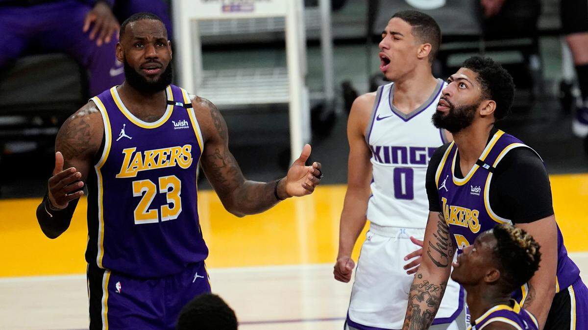 Sacramento Kings guard Tyrese Haliburton (0) reacts after scoring, between Los Angeles Lakers forwards LeBron James (23) and Anthony Davis, right, during the second half of an NBA basketball game Friday, April 30, 2021, in Los Angeles. (AP Photo/Marcio Jose Sanchez)