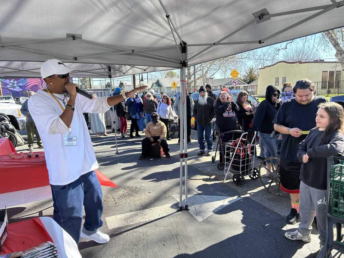 Azariah Smith, 40, leads a prayer Saturday for Lifting Spirits Higher, a local organization that provides meals and supplies weekly at 2110 Del Paso Blvd. in Sacramento.&nbsp;