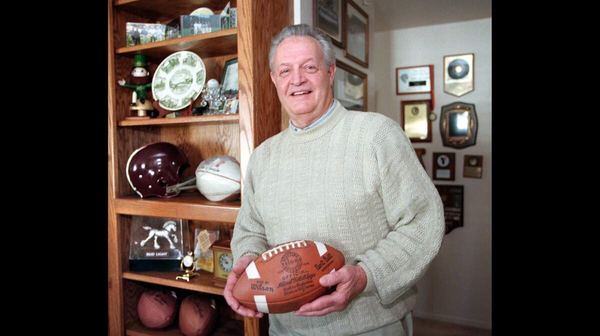 Gene Cronin, former NFL player with the Detroit Lions, and then director of player personnel and an assistant general manager for the Atlanta Falcons, strikes a pose in his Sacramento home in 1999 with some of his memorabilia from his NFL days. Cronin died in September 2024 at age 90.