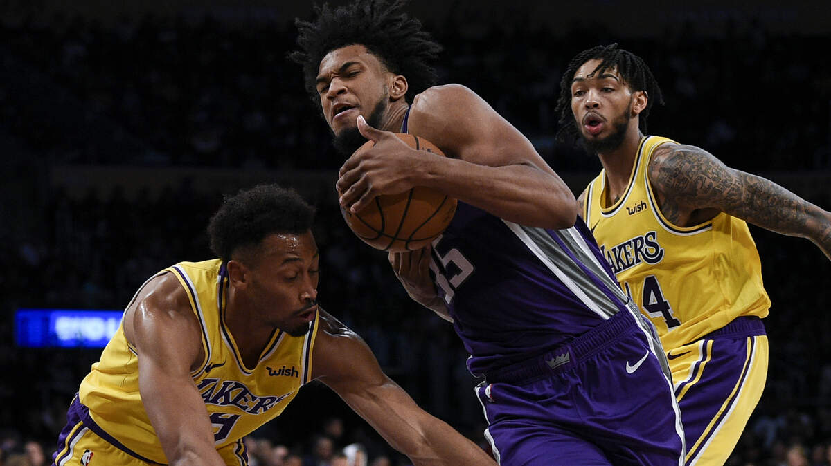 Kings forward Marvin Bagley III drives past Los Angeles Lakers forward Johnathan Williams, left, during the second half Thursday in Los Angeles. The Kings lost 128-123. Lakers forward Brandon Ingram, right, led all scorers with 31 points.