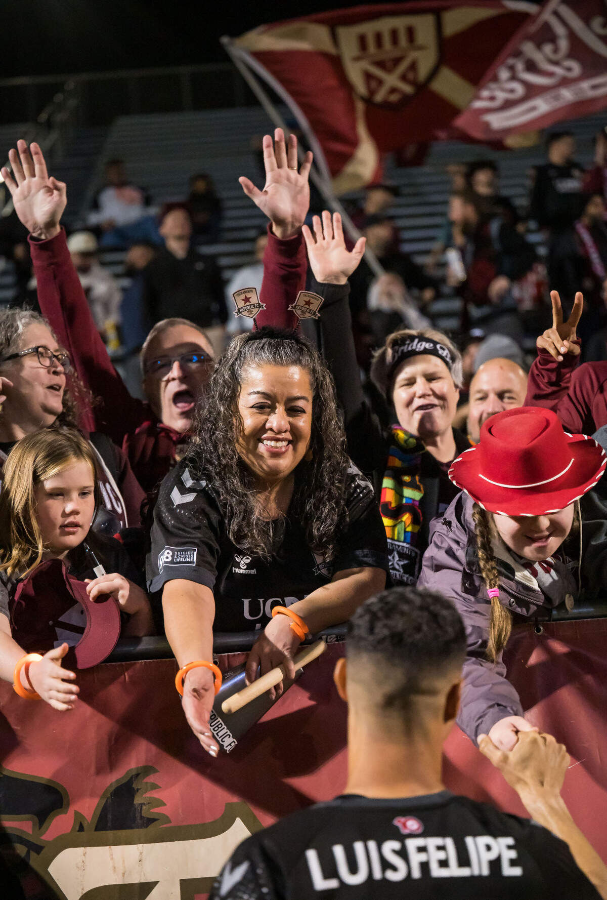 Sacramento Republic FC fan Rosa Altamirano, center, of Sacramento, holds out her hand to congratulate midfielder Luis Felipe (96) after their 5-0 win over Louisville City FC in the USL soccer match Saturday, April 1, 2023, at Heart Health Park.