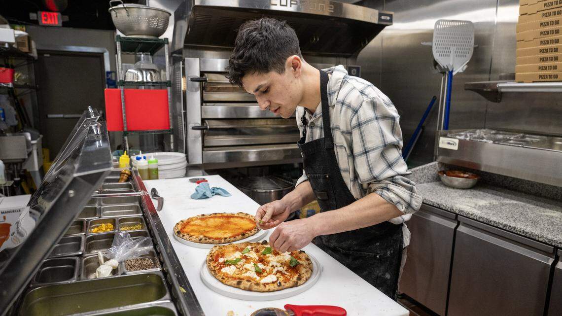 Manager Jackson Wells adds toppings to a pizza order at Dodici Pizza on Thursday, March 6, 2026, in Sacramento.