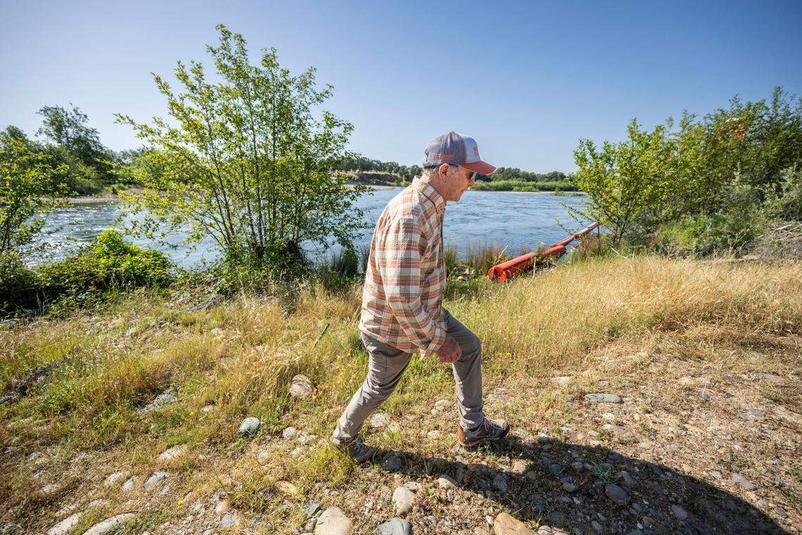 Frank Rinella, a Yuba River angler, walks near the Daguerre Point Dam on the lower Yuba River earlier this month. Rinella is concerned that a proposed “fishway” could give access to predatory striped bass and American shad to the area above the dam, impacting a popular fly fishing location.