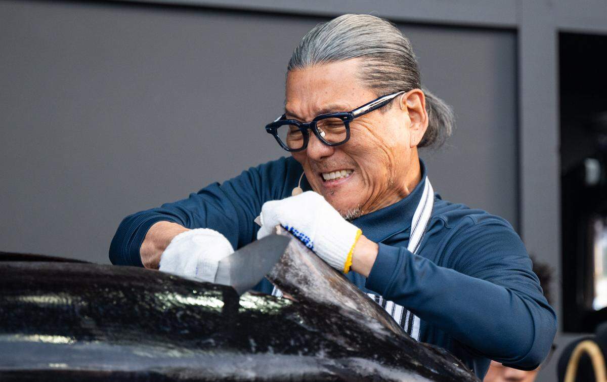 Celebrity chef Masaharu Morimoto, celebrating his 70th birthday, cuts off the head of a 200-pound tuna during a cooking demonstration at the BottleRock music festival in Napa on Friday, May 23, 2025. 