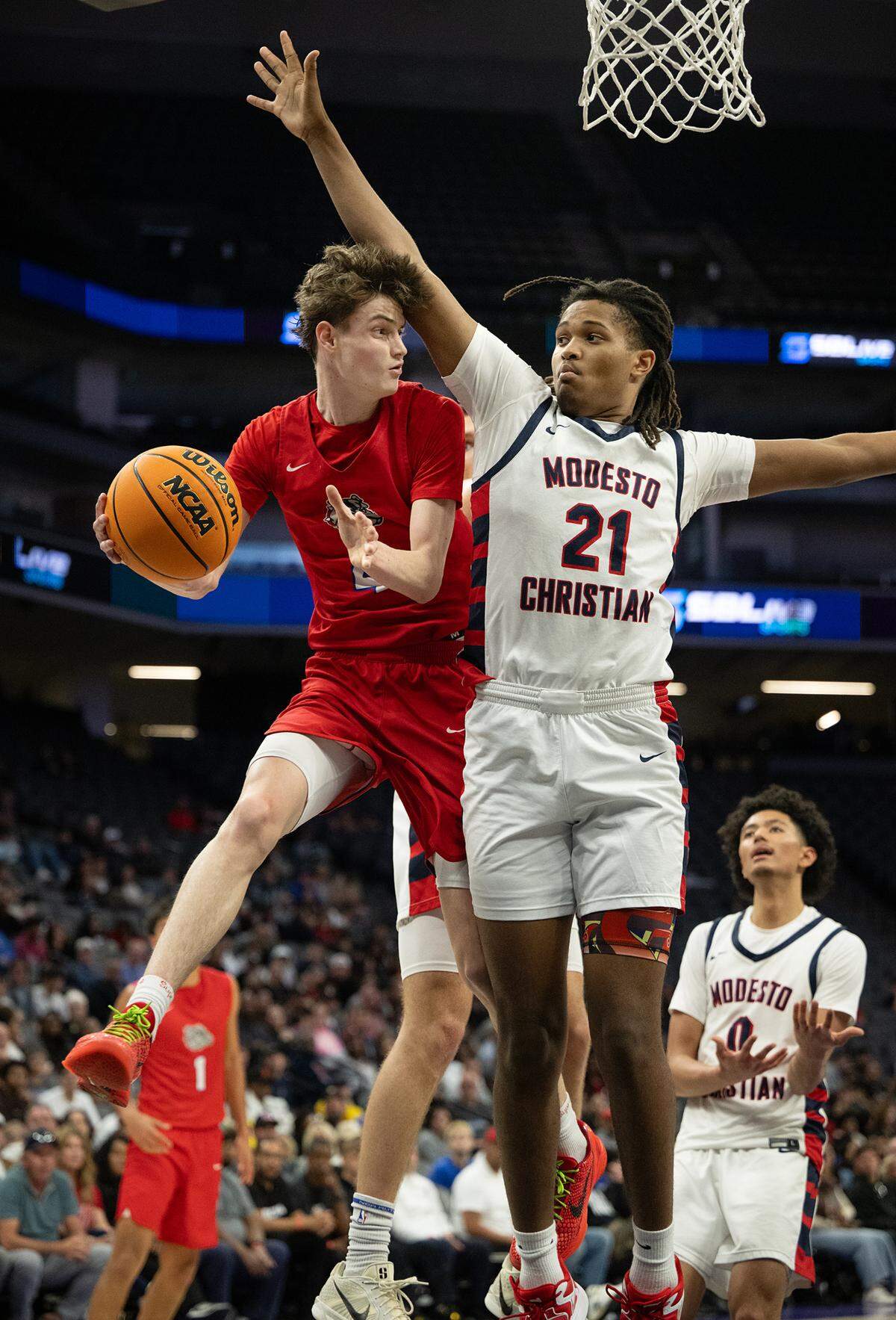 Folsom’s Chase Rawlins passes off the ball as Modesto Christian’s Blake Colbert defends during the Sac-Joaquin Section Division I championship game at the Golden 1 Center in Sacramento on Friday. Folsom won the title 62-52.