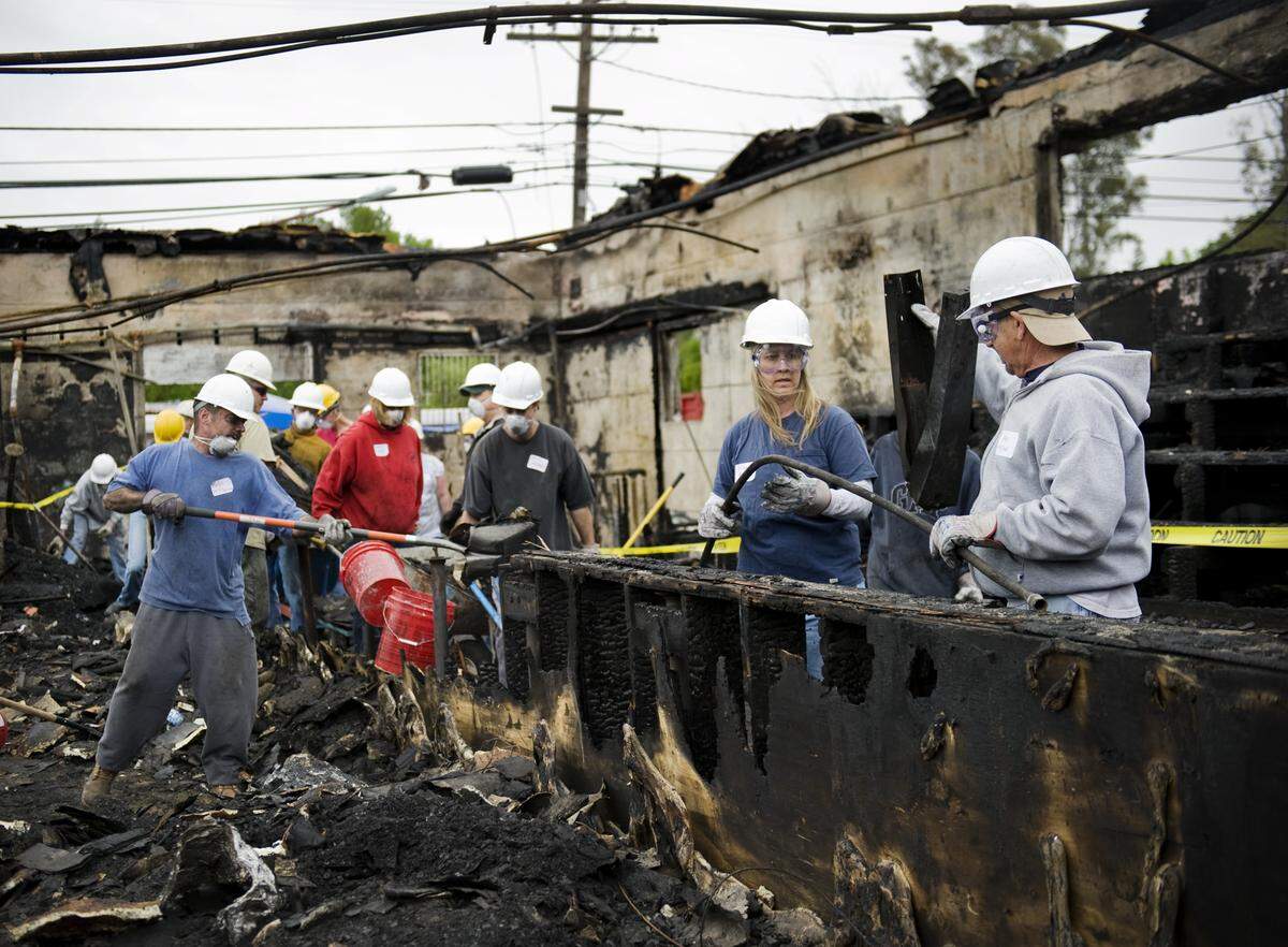Volunteers remove charred debris from the Iceland Ice Skating Rink in North Sacramento in April 2010. More than 100 community volunteers attended the clean-up day despite the wind and rain.