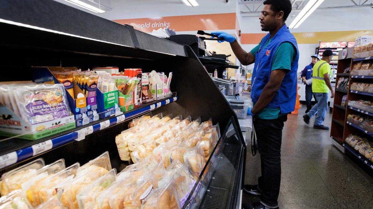 Cashier Kenny Young works inside the convenience store at the Rotten Robbie gas station on Old Oakland Road in San Jose. Proposition 32 seeks to boost California’s minimum wage to $18 per hour by 2026.