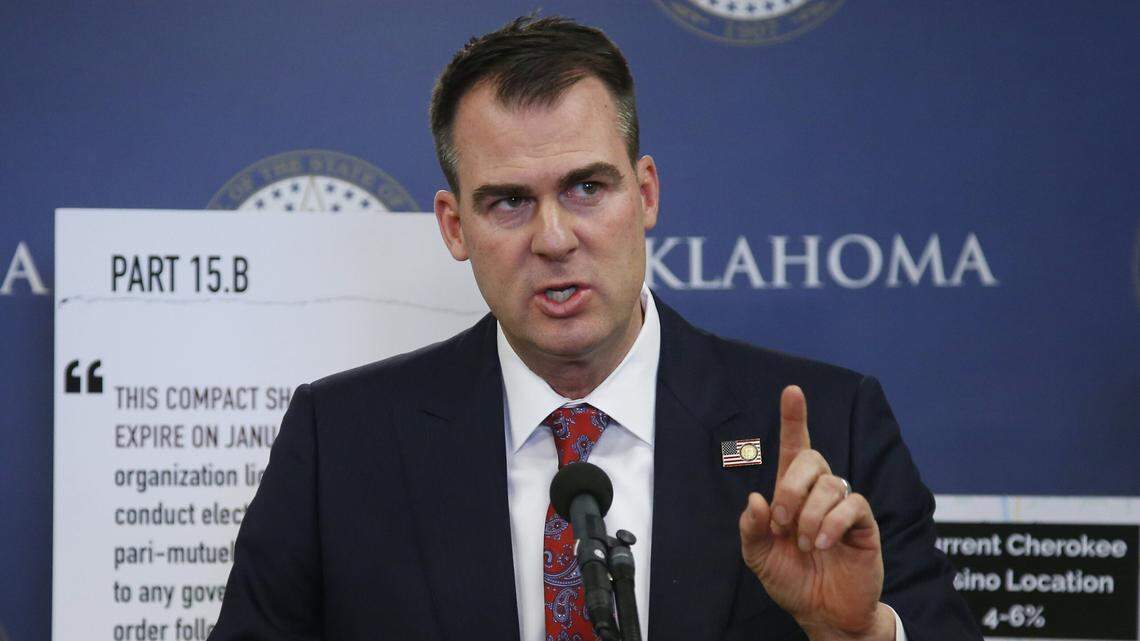 FILE - In this Dec. 17, 2019, file photo, Oklahoma Gov. Kevin Stitt gestures during a news conference in Oklahoma City. Stitt on Thursday, Jan.23, 2020, banned state-funded travel to the state of California, saying it’s in response to similar bans California has put in place on travel to the Sooner State. The first-term Republican issued an executive order that prohibits all non-essential travel by state employees to California, with exceptions for business recruiting trips, college sports games and trips by schools to participate in programs.(AP Photo/Sue Ogrocki, File)