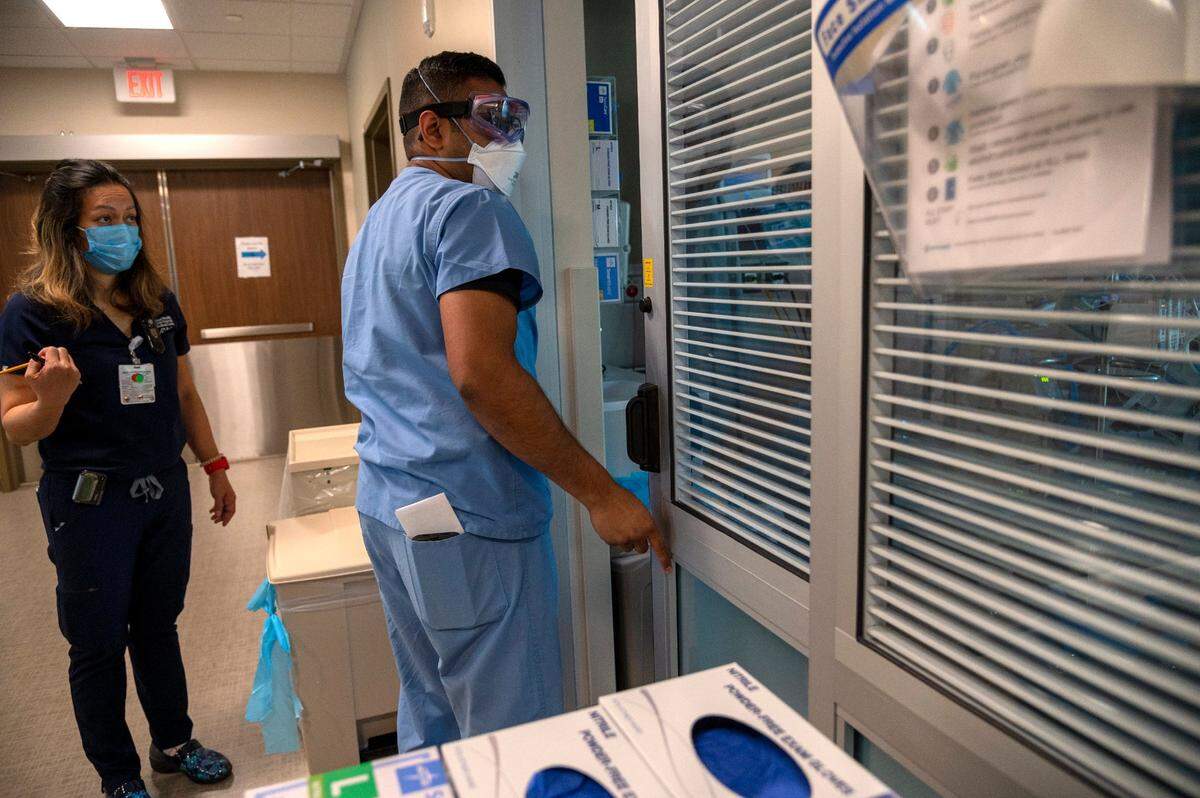 Respiratory therapist Alex Singh, center, checks on a COVID-19 patient in ICU alongside Registered Nurse Glenda Real at Sutter Roseville Medical Center on Tuesday, Dec. 22, 2020.