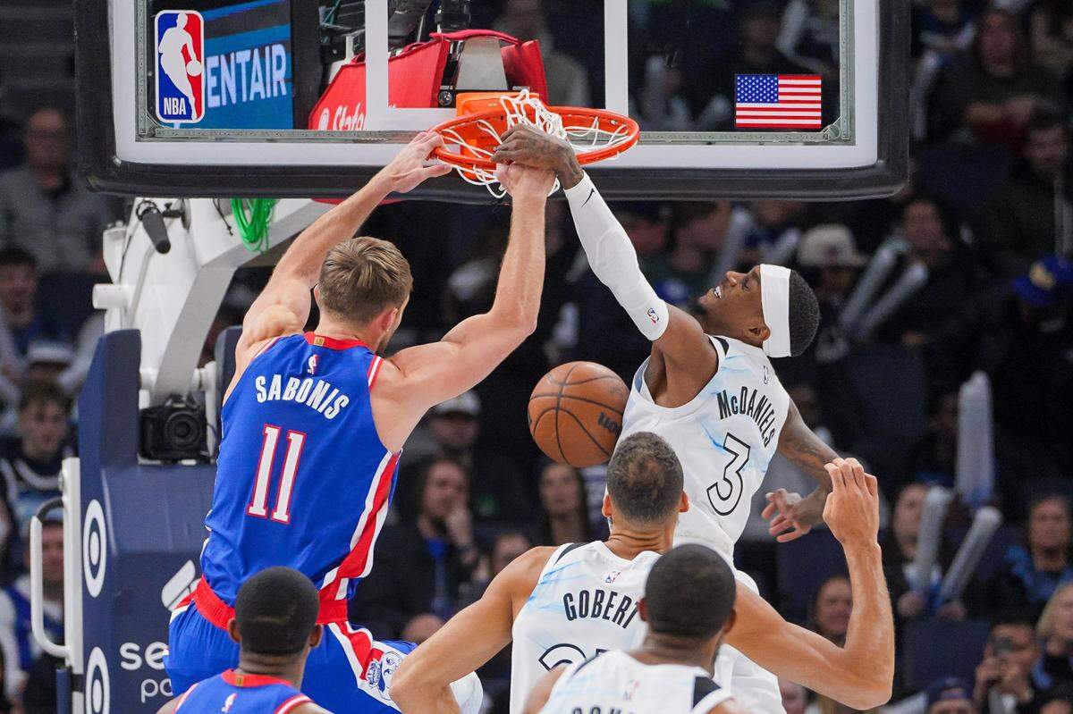 Nov 27, 2024; Minneapolis, Minnesota, USA; Sacramento Kings forward Domantas Sabonis (11) dunks against the Minnesota Timberwolves forward Jaden McDaniels (3) in the first quarter at Target Center. Mandatory Credit: Brad Rempel-Imagn Images