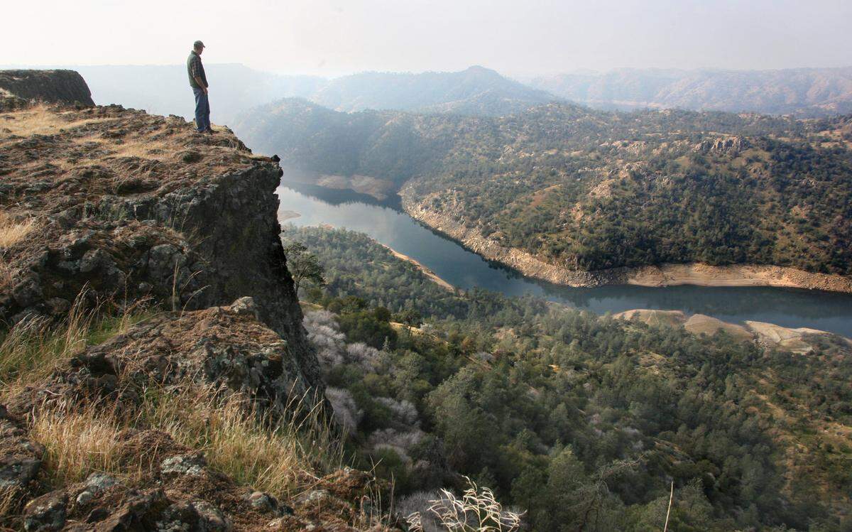 Logan Page, then-stewardship director of the Sierra Foothill Conservancy, looks over the edge of Big Table Mountain into the gorge containing the upper reaches of Millerton Lake near Temperance Flat in 2009. The proposed Temperance Flat Dam, which would be beyond the first ridge in the center of the photo, received a sliver of the funding it needs from Proposition 1 – putting the project’s future in jeopardy.