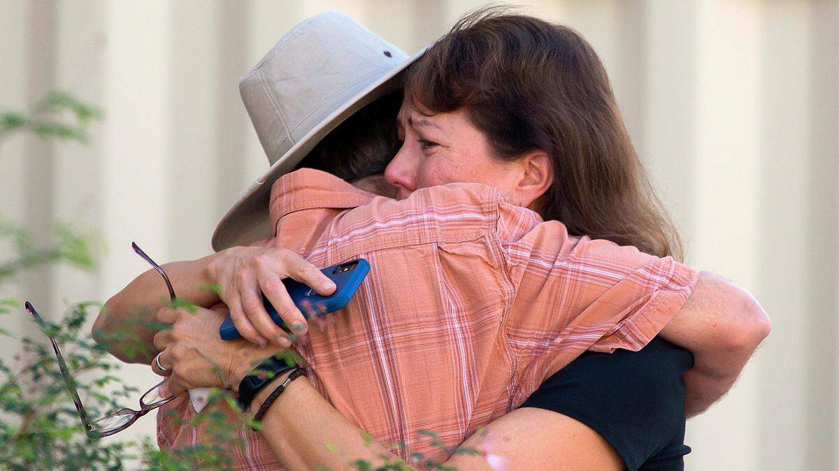 Two people hug after a shooting at the John W. Harshbarger Building on the University of Arizona campus in Tucson, Ariz., on Wednesday, Oct. 5, 2022. University of Arizona police say one person was shot and wounded on campus and authorities are searching for the suspect.