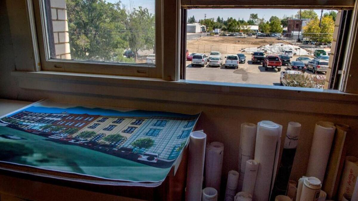 
A blocklong site cleared for a new hotel in downtown Winters is seen through a window in City Hall. Below the window is a rendering of the planned hotel. Construction begins this fall.
