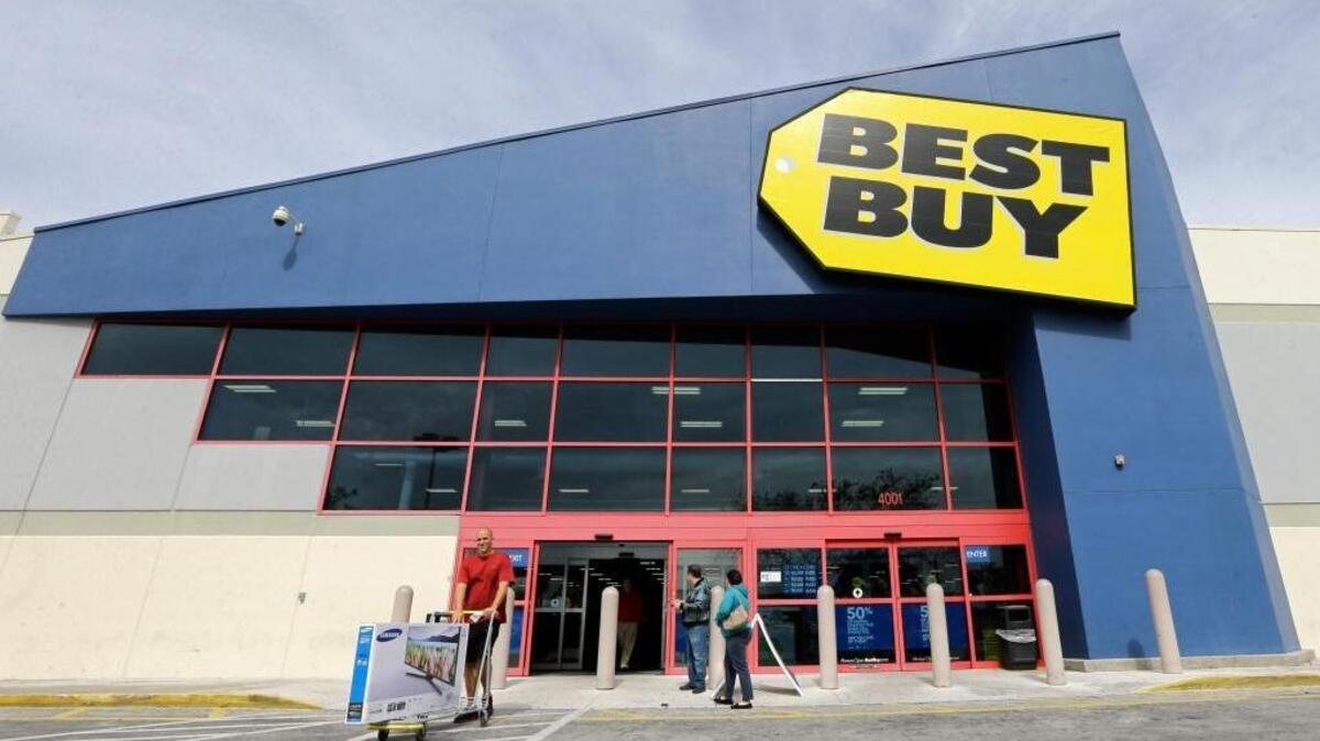 FILE - In this Tuesday, Feb. 9, 2016, file photo, a shopper carts his purchased LED TV at a Best Buy in Miami. Billboard has reported that Best Buy will cease selling CDs as of July 1, 2018.