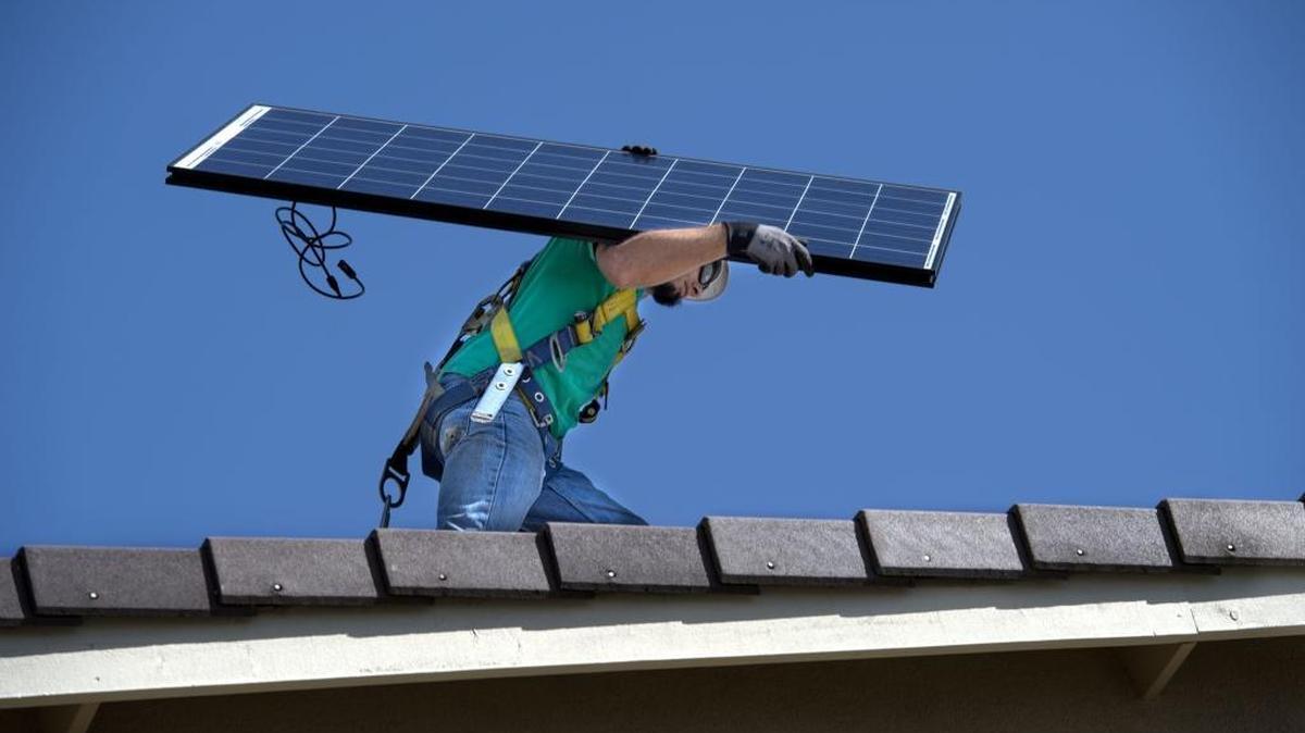 Nate Lehrer, a senior installer with SolarCity, carries a solar panel to a job in West Sacramento in April.