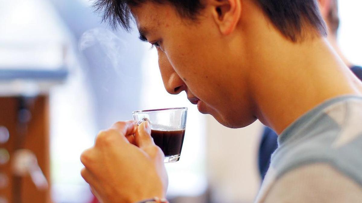 Brandon Lew takes in the aroma of the coffee he brewed for an experiment in his Design of Coffee class at UC Davis on Thursday, Feb. 6, 2014.