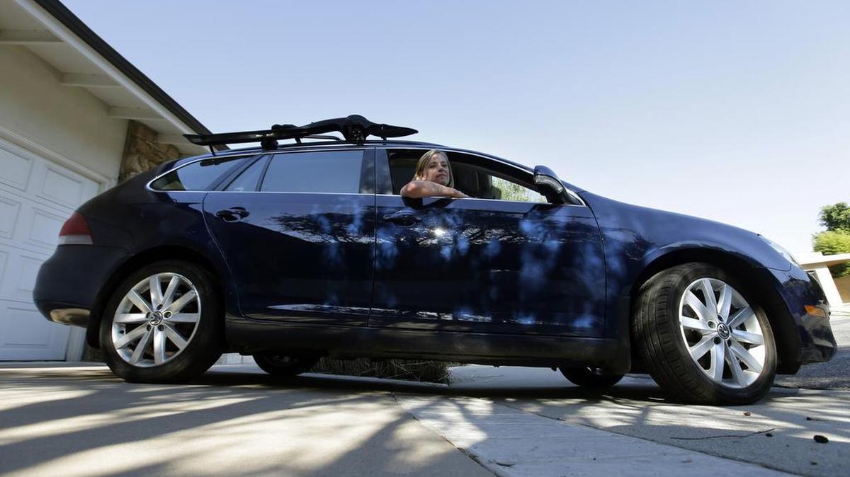 
FILE - In this Sept. 23, 2015, file photo, Zandy Hartig poses for a picture in her 2013 Volkswagen Jetta Sportwagen diesel in Studio City.
