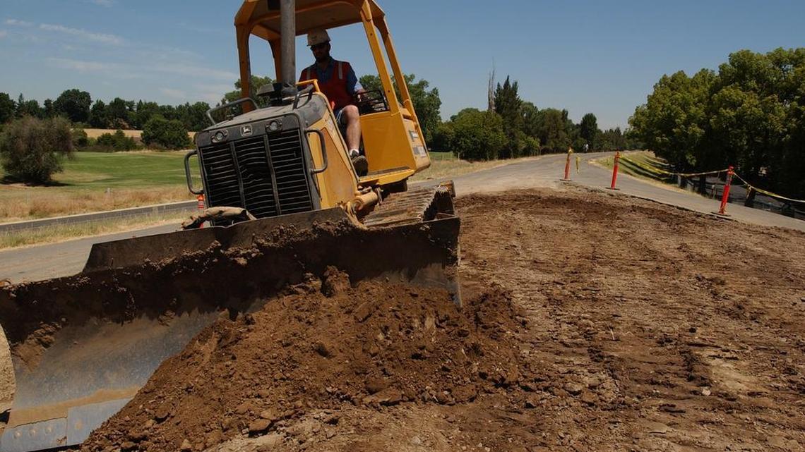 2016 file photo. A bulldozer works on the H Street project, where they raised the levee level by the bridge by one foot in June 2004. In 2022, the American River levee near the bridge is under construction once again for erosion protection.
