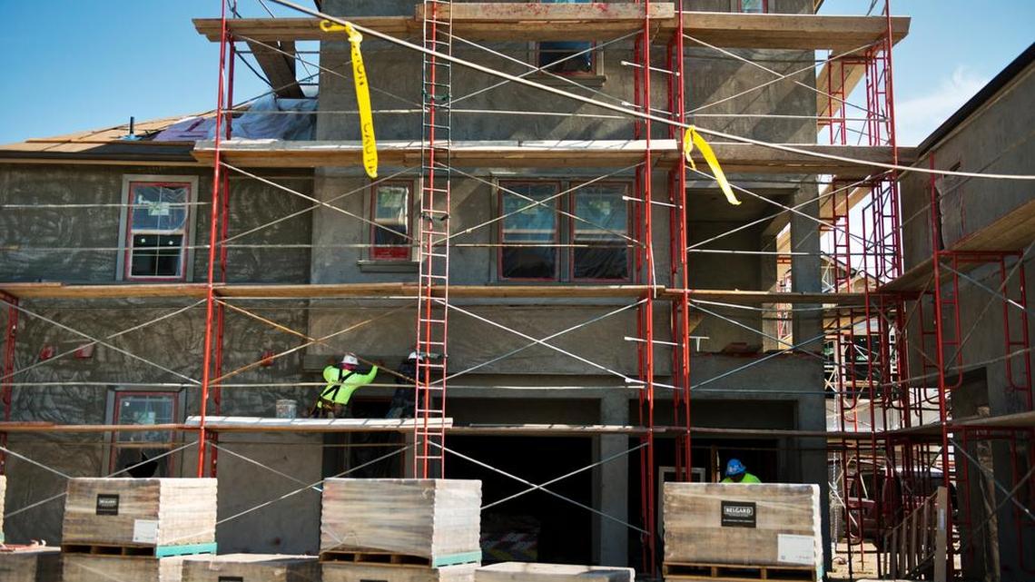
Construction workers put on trim on a townhouse at The Mill at Broadway on Wednesday. Construction superintendent Gregg Uttecht said he is feeling the pressure of falling behind on the development because of a lack of workers. “These are big buildings, and to get them (built) in the time frame the owners want, I’d need six electricians, and the most I have is two,” Uttecht said.
