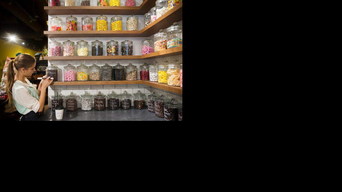 
Natalie Tramontano marks candy jars at Andy’s Candy Apothecary in Sacramento’s downtown business district Saturday. The candy store is nearing its first full year in business.
