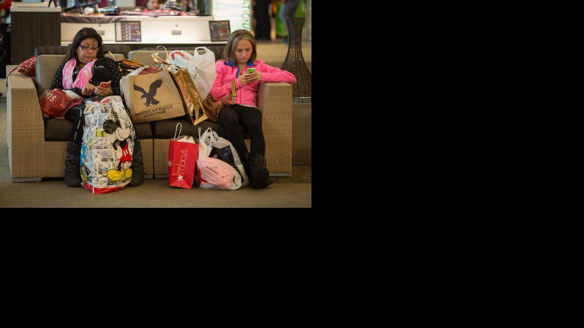 
Victoria Alonso, left, and her stepdaughter Samantha Hughes take a break from shopping Fridayat the Westfield Galleria in Roseville. Starting at 3 a.m., the pair were near the end of a five-hour shopping spree.
