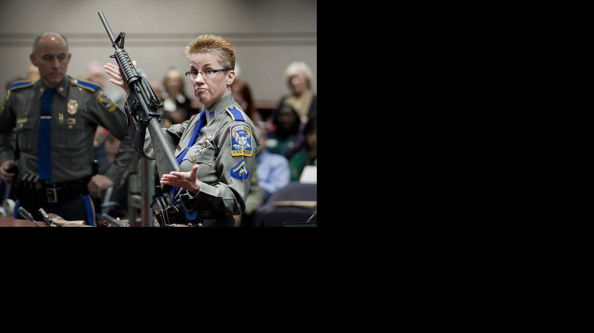 Firearms training unit Detective Barbara J. Mattson, of the Connecticut State Police, holds up a Bushmaster AR-15 rifle in January 2013, the same make and model of gun used by Adam Lanza in the Sandy Hook school shooting in December 2012, for a demonstration during a hearing of a legislative subcommittee reviewing gun laws, at the Legislative Office Building in Hartford, Conn.