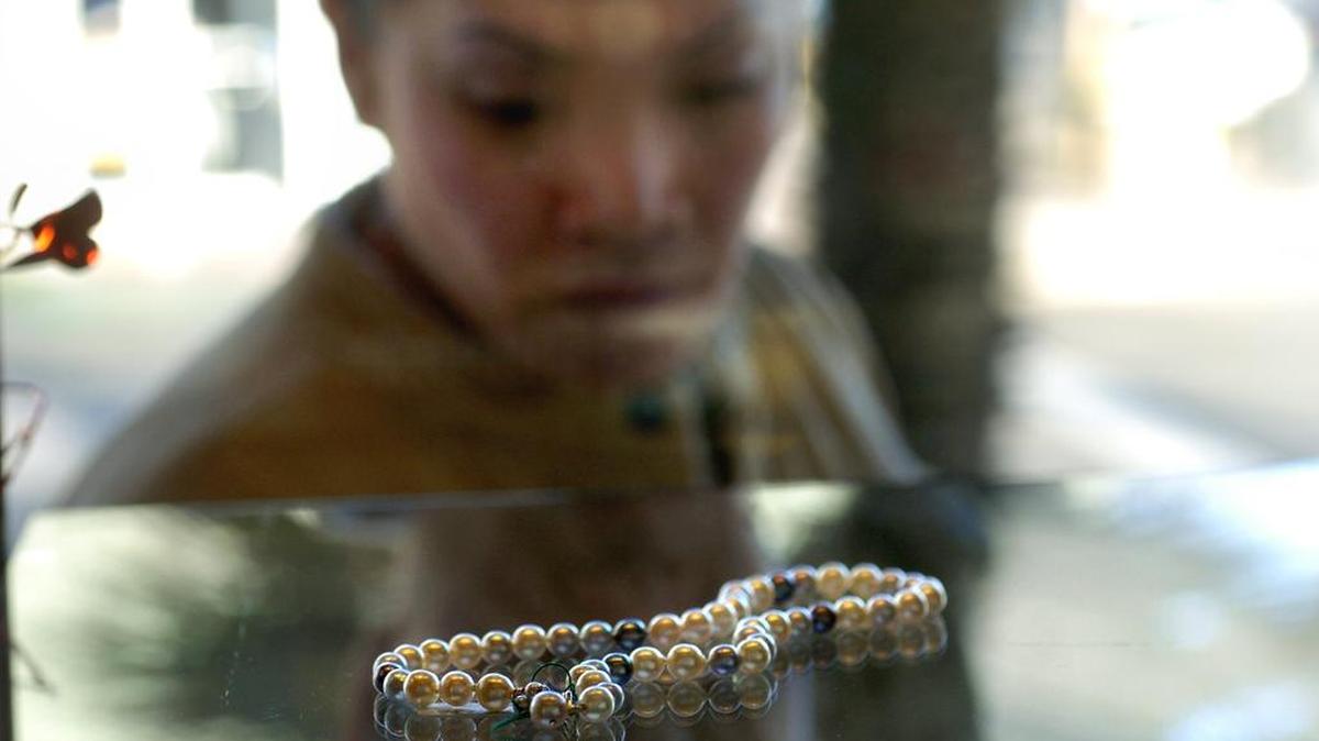 A window shopper peruses a pearl necklace in the window of De Luna Jewelers in Downtown Davis. Luna’s sales of jewelry and an extensive collection of Native American items will come to a close at the end of this month, ending a 48-year run.