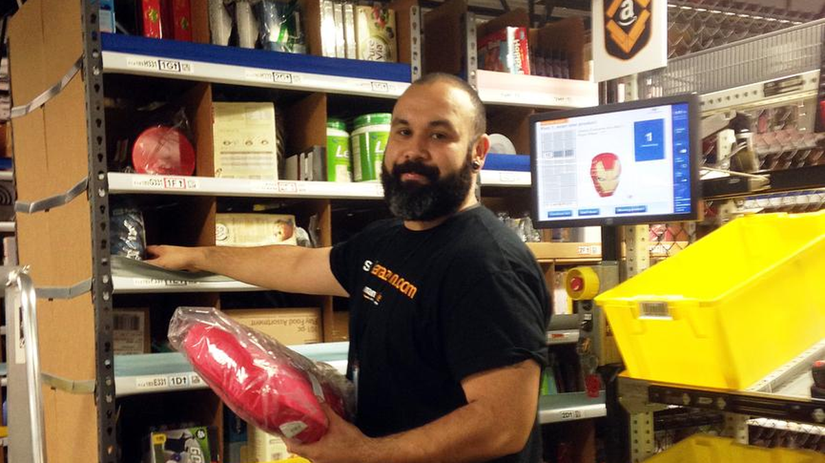 Amazon.com worker Rejinaldo Rosales retrieves items from pods that are carried to him by robots at Amazon’s warehouse in Tracy in November 2014.